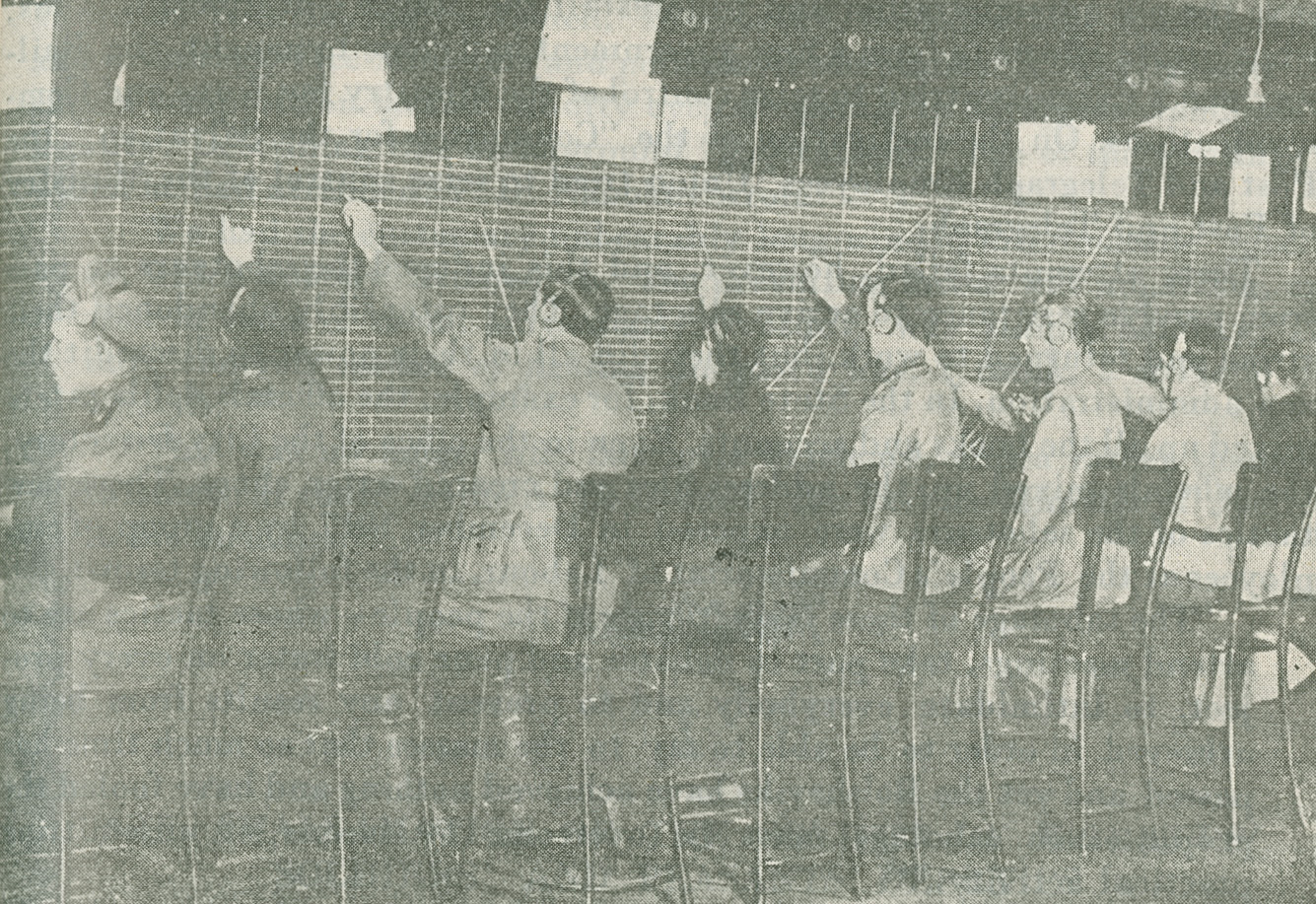 Photograph of men and women working the switchboard at the Central Telegraph Exchange when the telephone operators went on strike
